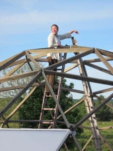 Growing Dome owner on ladder inside Growing Dome during construction