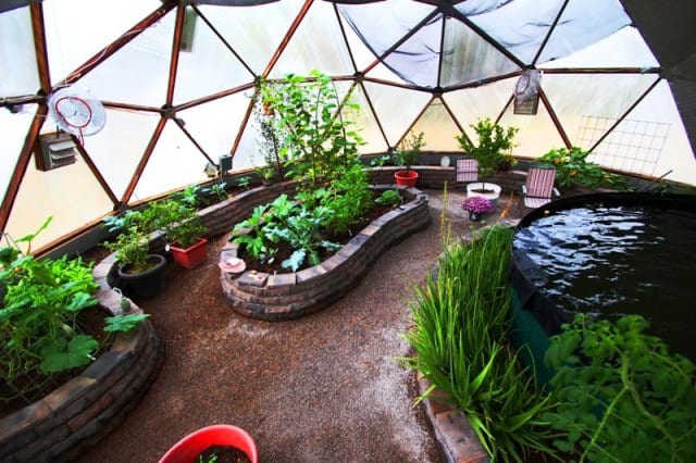 Interior of 33' Growing Dome greenhouse with raised garden beds made of stone