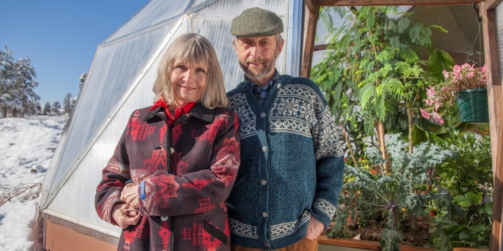 Puja Parsons and Udgar Parsons Owners of Growing Spaces pose in front of a Growing Dome greenhouse