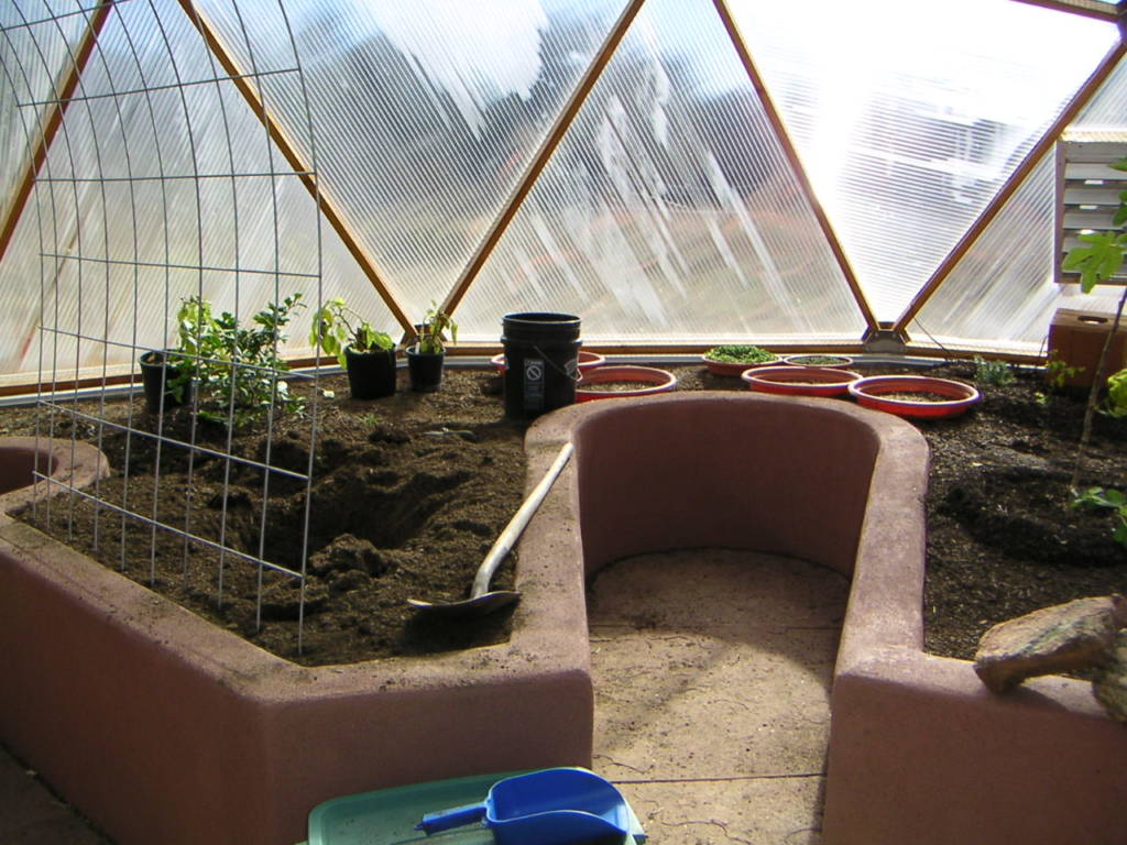 stucco raised beds with keyholes in Growing Dome greenhouse