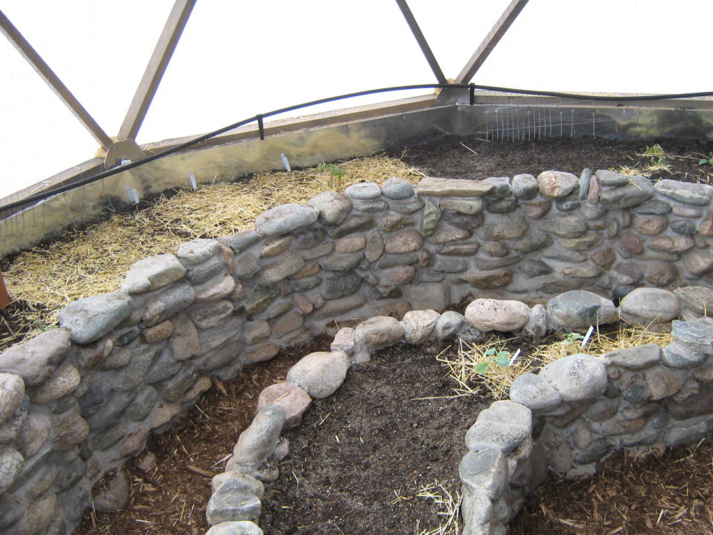 stone planting bed in geodesic dome greenhouse