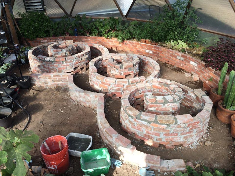 spiral brick planting beds in geodesic dome greenhouse