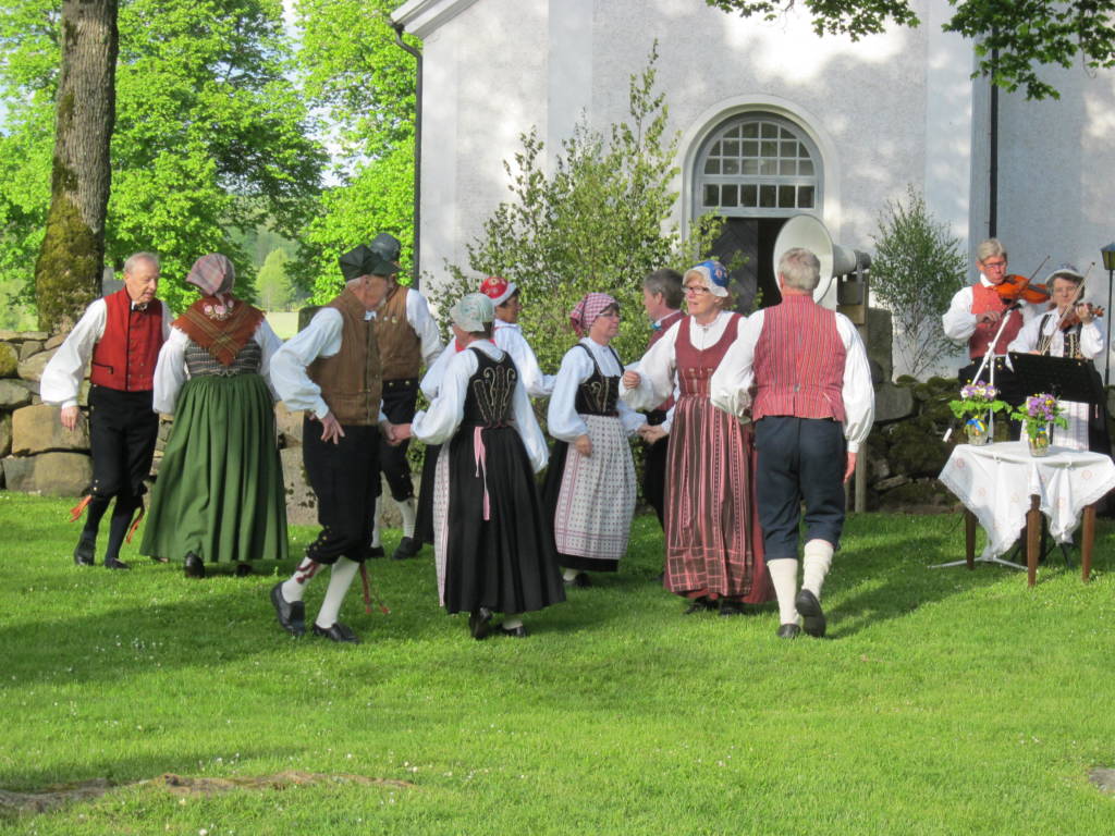 People in traditional Swedish garb dancing outside 