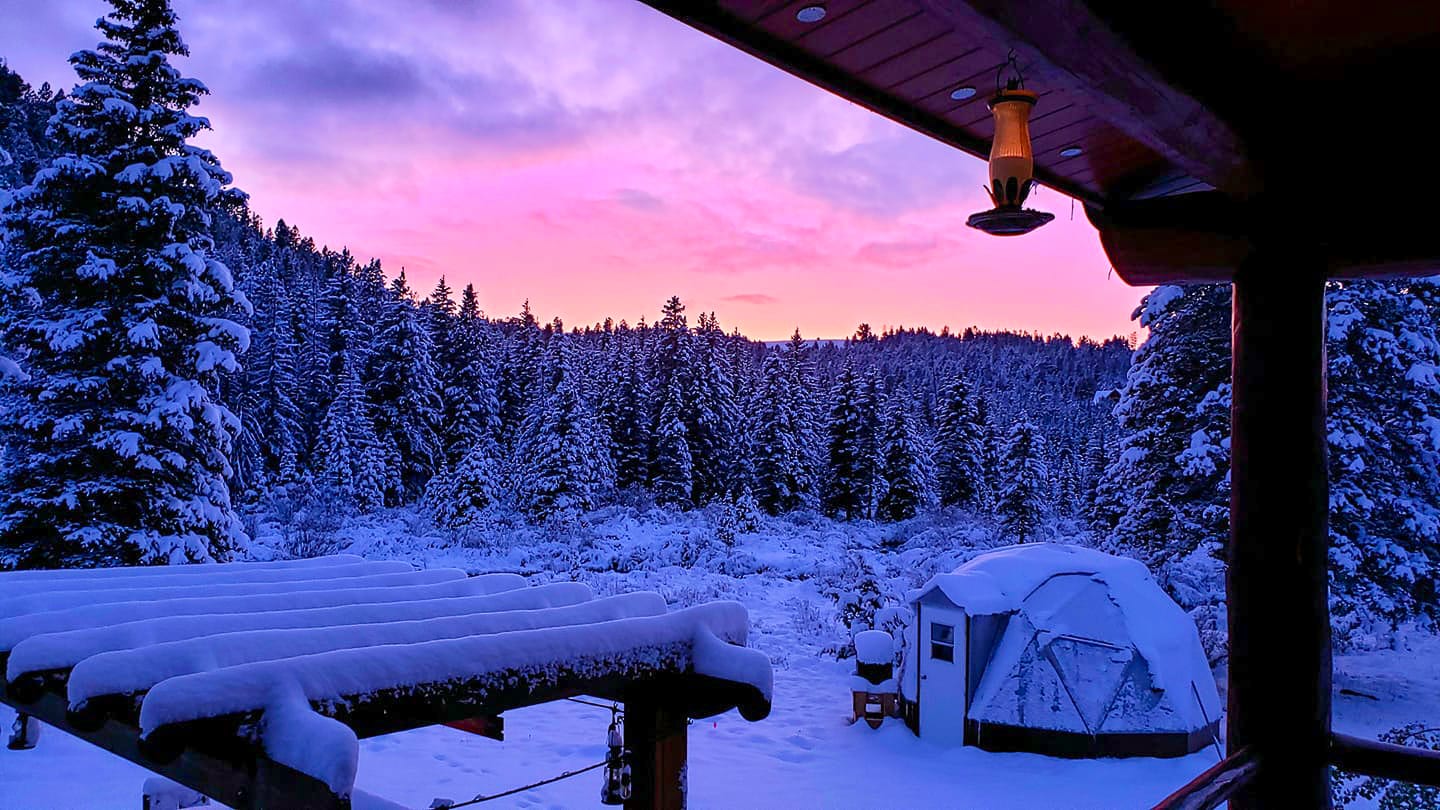 Jerry Bailey - sunset greenhouse - Growing Spaces Greenhouses 15 foot diameter geodesic greenhouse in Montana covered in snow with beautiful sunset colors in the sky.
