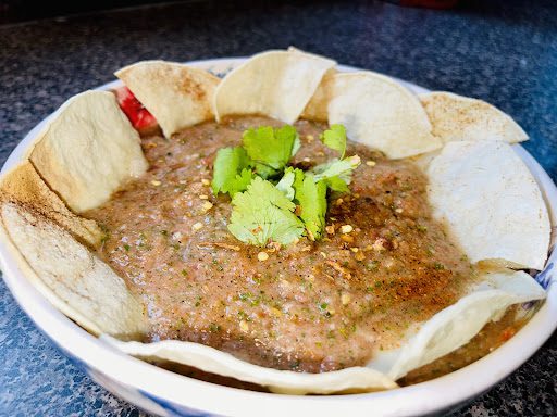 Salsa in a bowl with chips and cilantro