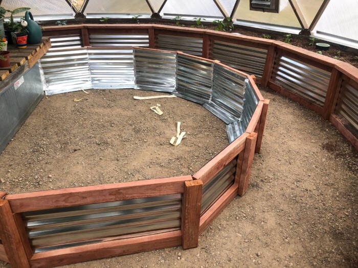 Building garden beds in a backyard greenhouse