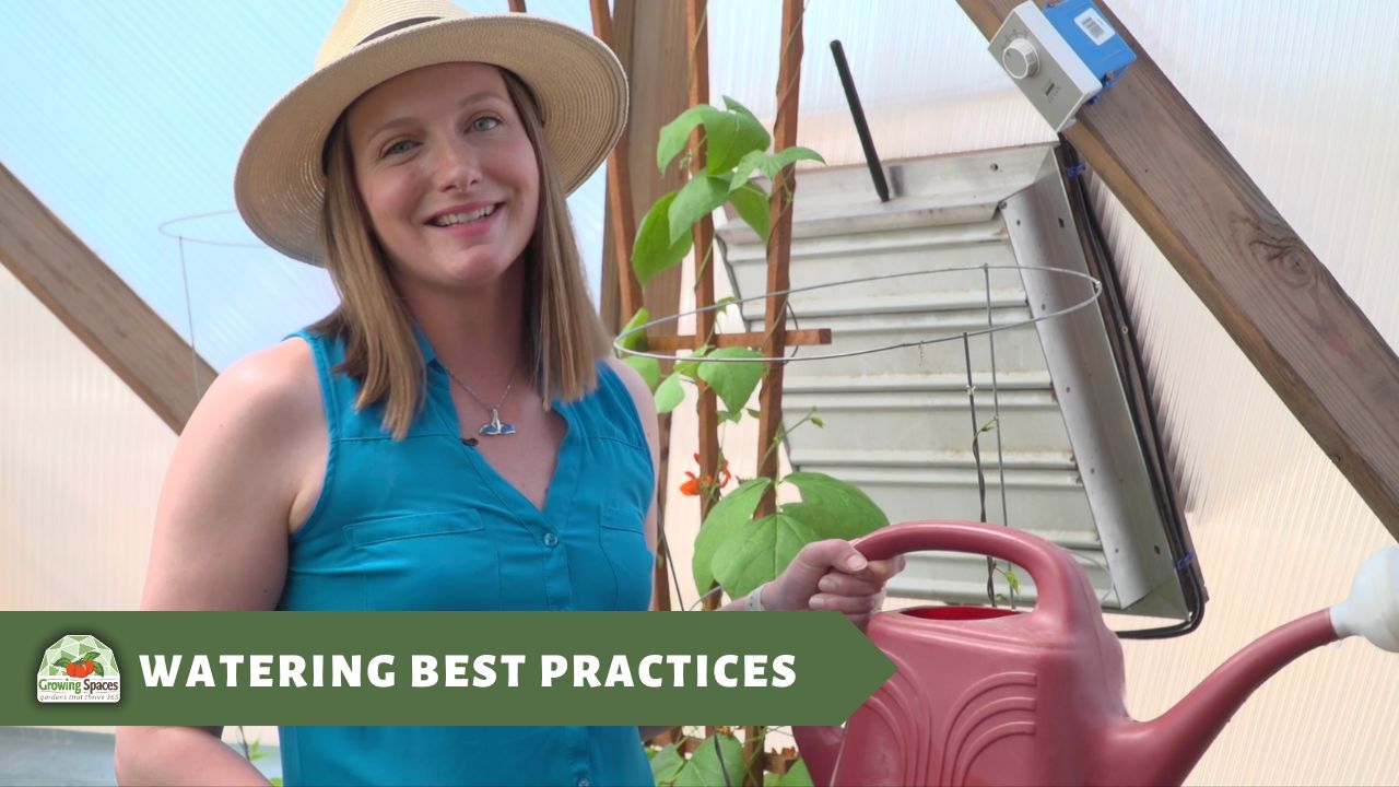 woman holding a watering can inside a Growing Dome