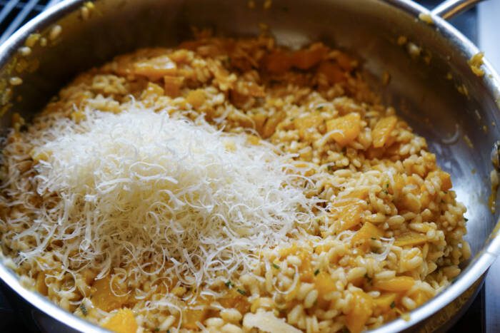 adding Parmesan cheese to pumpkin spice risotto