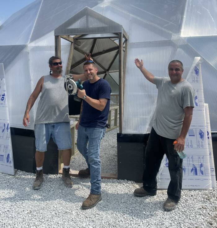 ReEntry program volunteers posing infront of built greenhouse