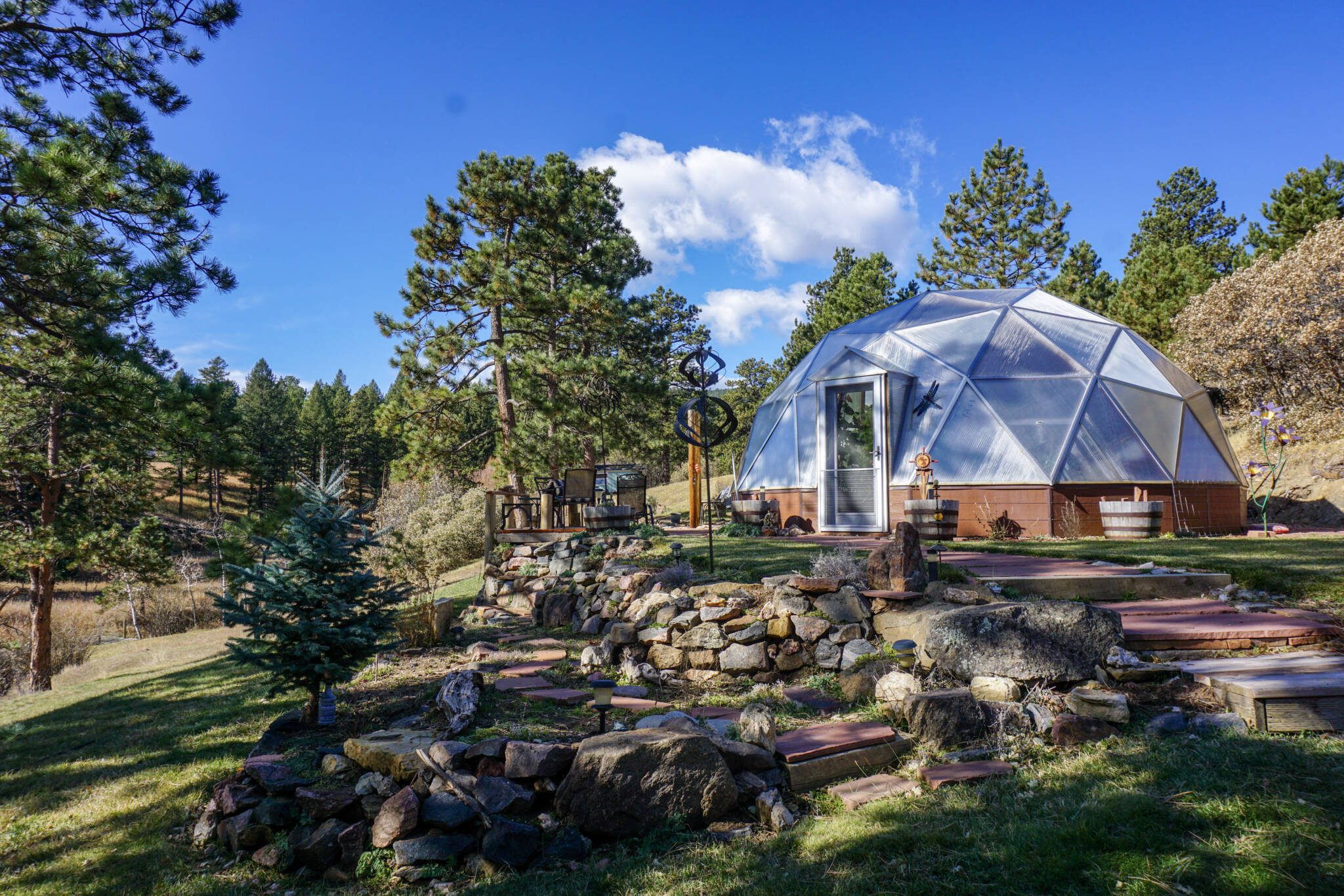 DSC05341 - Growing Spaces Greenhouses Geodesic Growing Dome Greenhouse Kit in the summer in Colorado beautifully landscaped with rock walls and paved paths