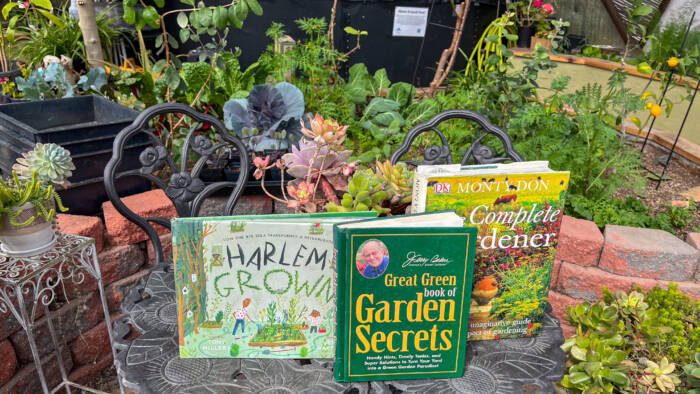 Three gardening books on a table in a Growing Dome greenhouse