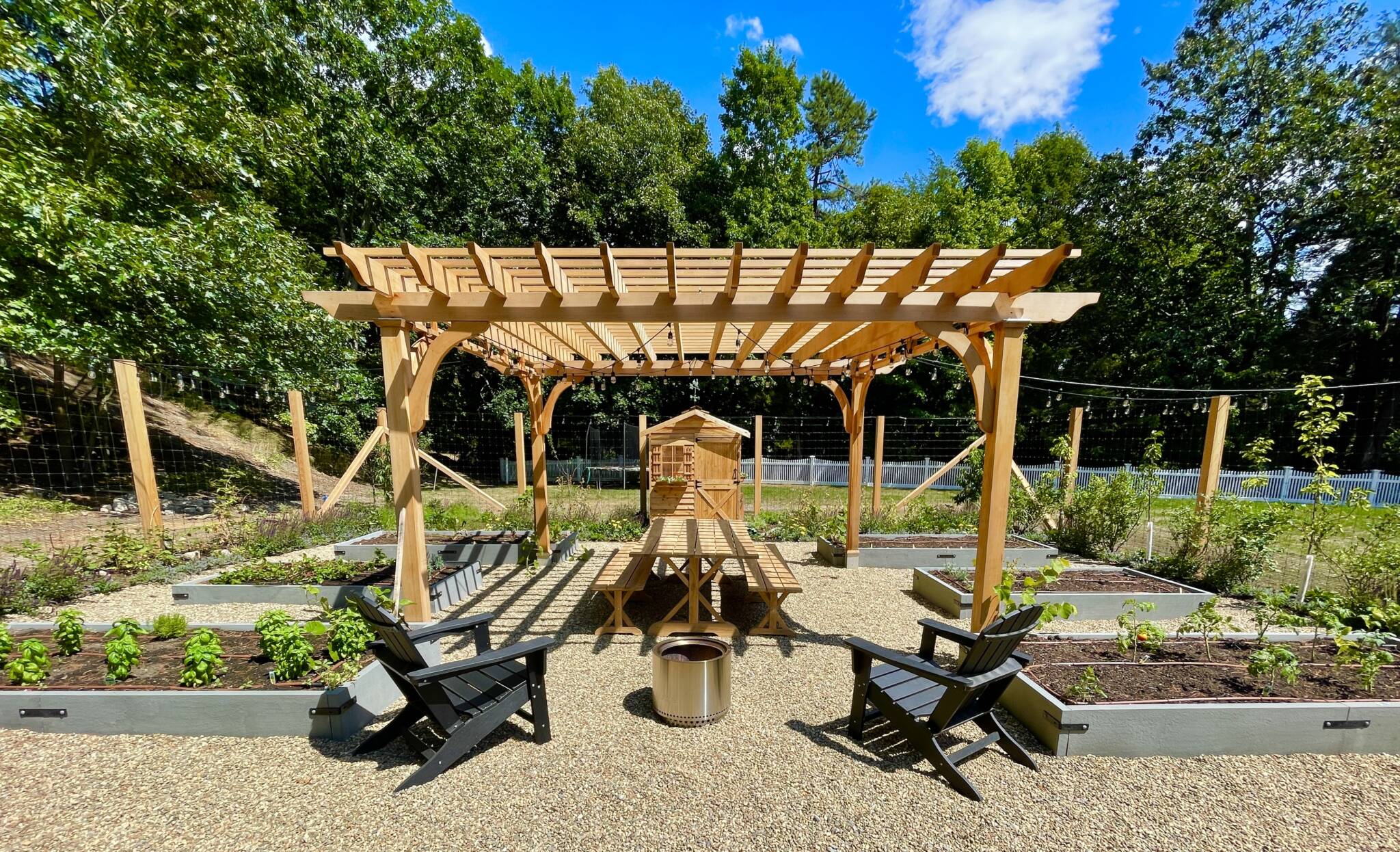 Cedar pergola, bluestone raised beds, deer fence, edible garden surrounded by fruit trees, berries, and flowers