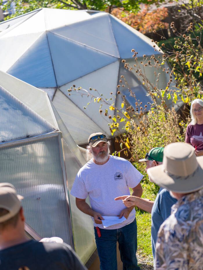 people standing outside of a Growing Dome, asking questions of the speaker