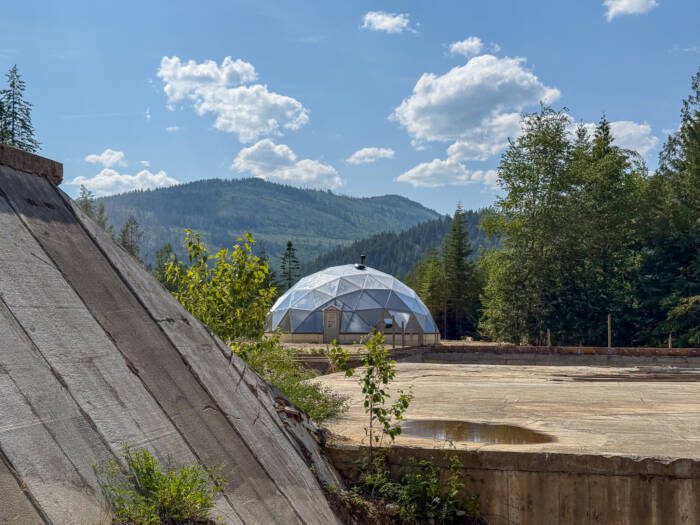 BunkerIdahoDome - Growing Spaces Greenhouses 42' Growing Dome in the Idaho mountains with a concrete bunker house in foreground