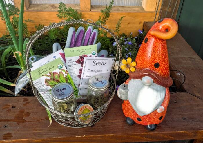 DIY gift basket idea for gardeners featuring gardening gloves, dried herbs, seeds, and a garden gnome